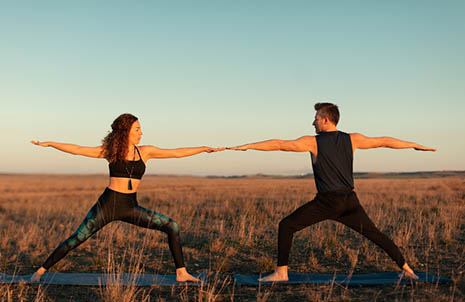 Couple Doing Yoga Outside At Sunset